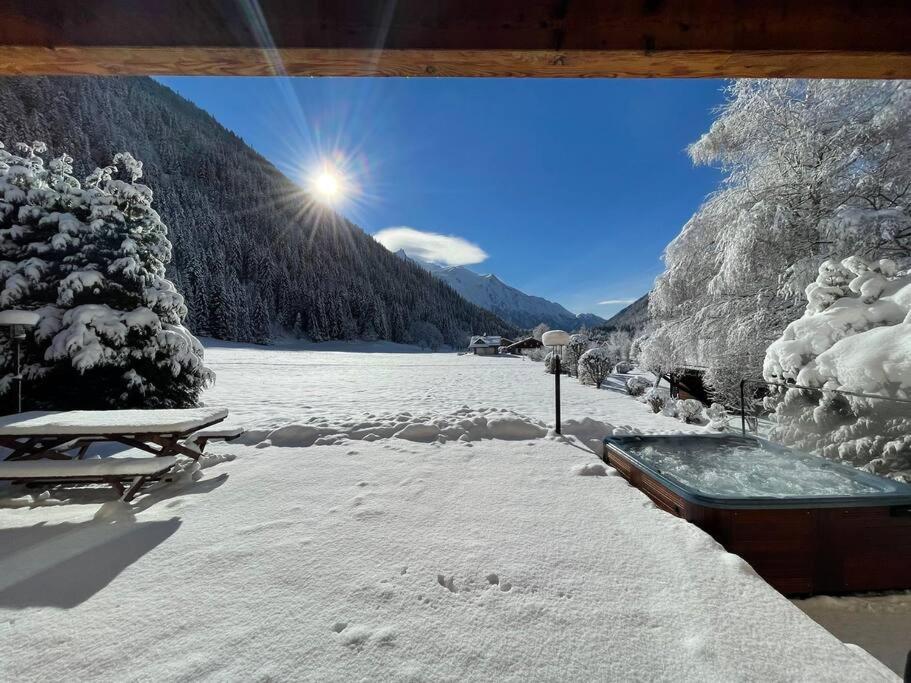 une zone enneigée avec un bain à remous à côté d'une montagne dans l'établissement Chalet Melusine - Big Chalet w Spa Pool, Sauna, Huge Terrace, Views & Privacy!, à Argentière