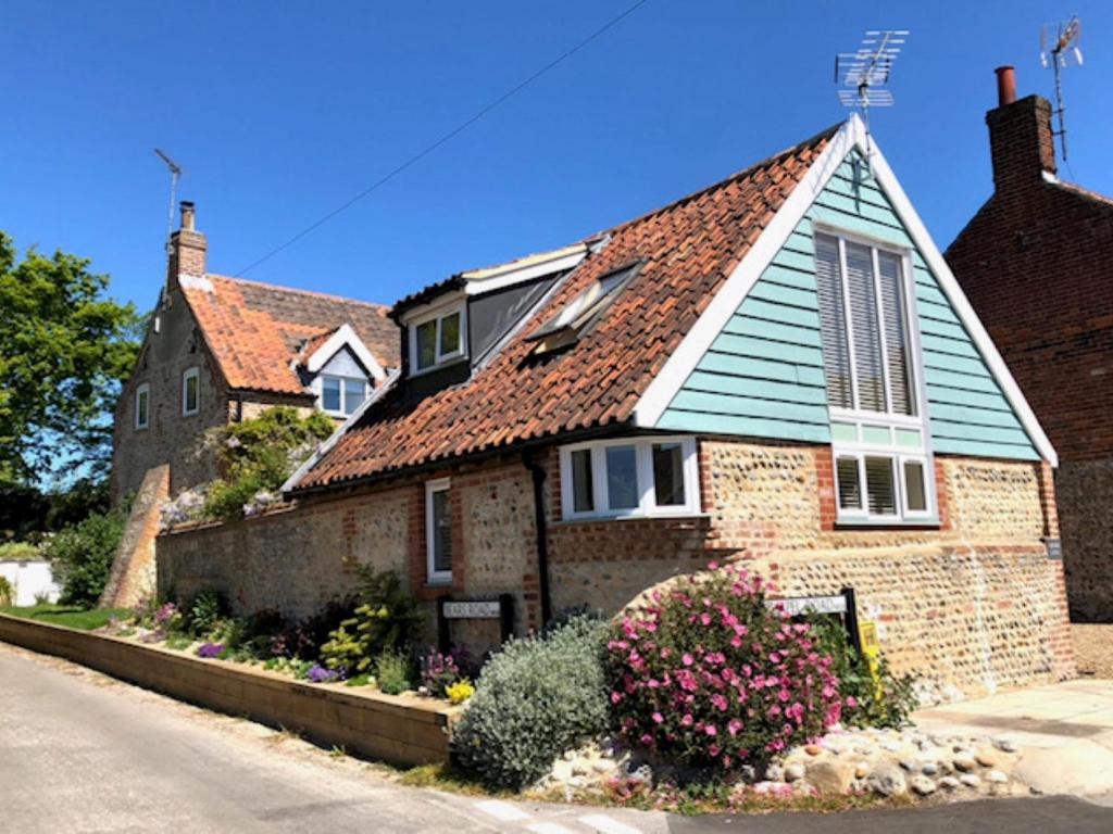 an old brick house with a blue roof at 1 bed property in Cromer 48723 in Bacton