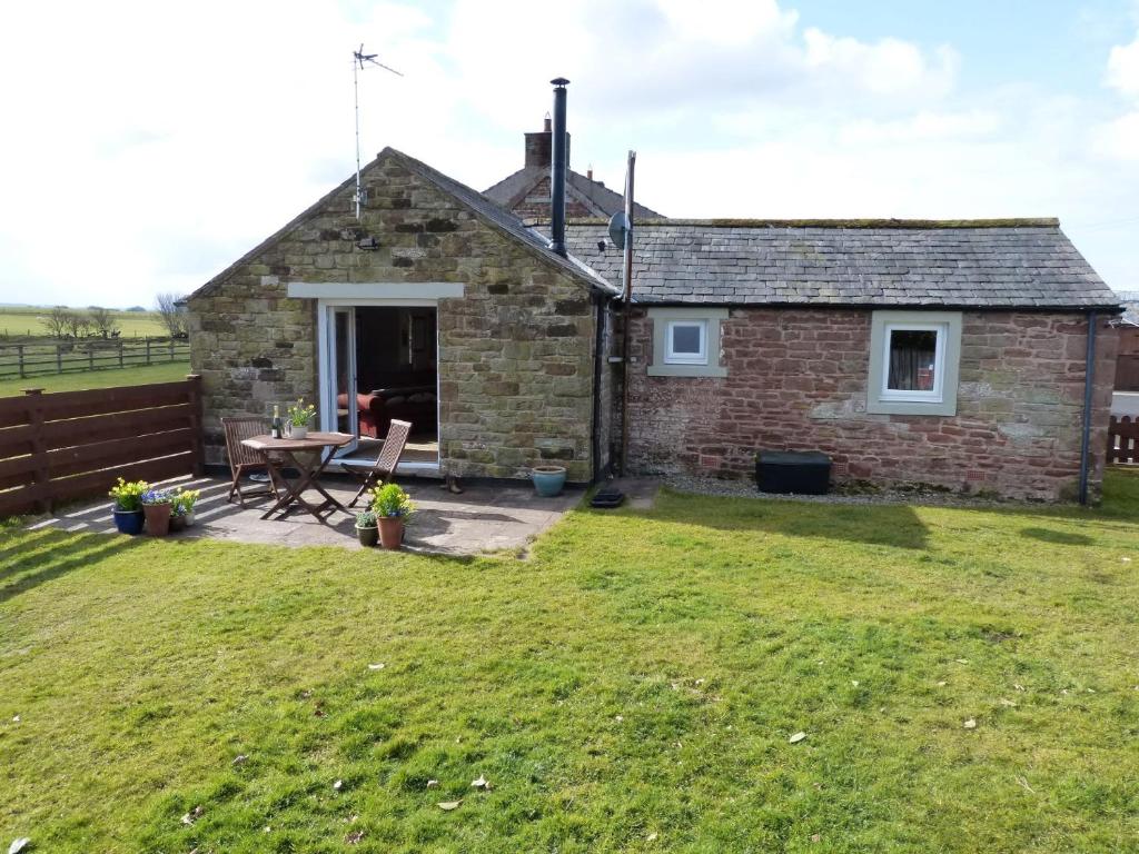 a stone cottage with a picnic table in a yard at 1 bed in Brampton 56564 in Irthington