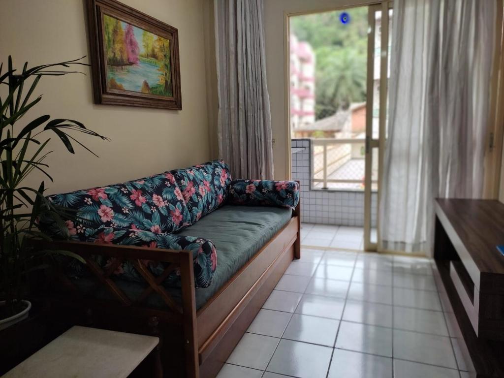 un salon avec un canapé et une table dans l'établissement Apto 105 - Edifício Imola - Conforto e Segurança para sua família, à Ubatuba