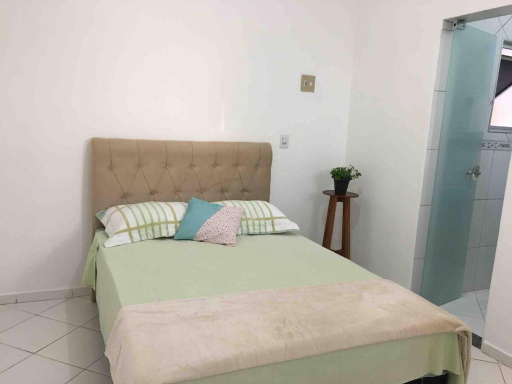 1 dormitorio con 1 cama con cabecera y almohadas en Apartamento Aconchegante 2 quartos, en Vitória da Conquista