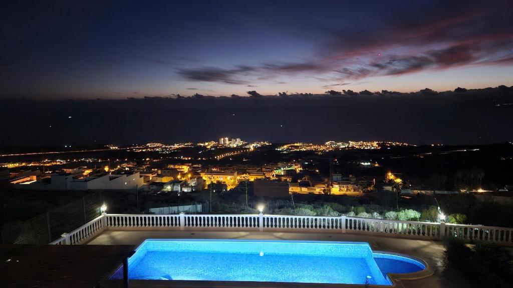 una piscina por la noche con vistas a la ciudad en Cool 4-bedroom Villa with sea views, en Tijoco de Abajo