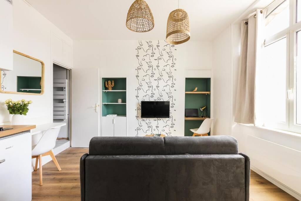 ein Wohnzimmer mit einem Sofa und einem Tisch in der Unterkunft Studio escale élégante - proche gare Saint-Brieuc in Saint-Brieuc