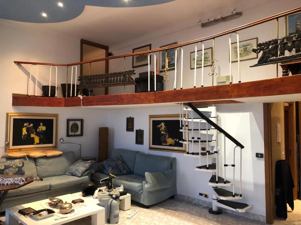 - un salon avec un canapé bleu et un escalier en colimaçon dans l'établissement Boulevarde de la Turbie Beausoleil, à Beausoleil