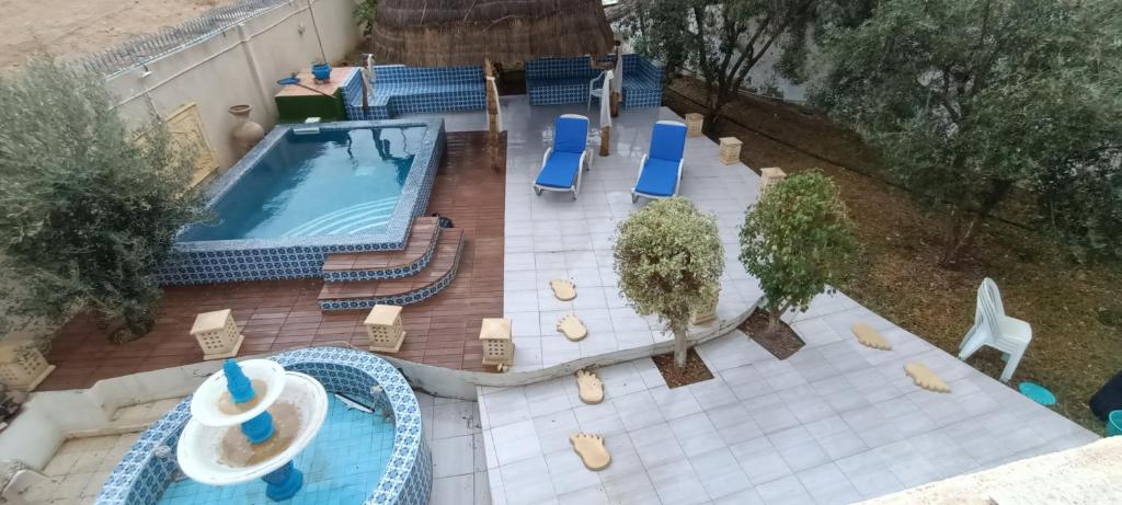an overhead view of a swimming pool with chairs and a table at La Brise Marine in Sousse