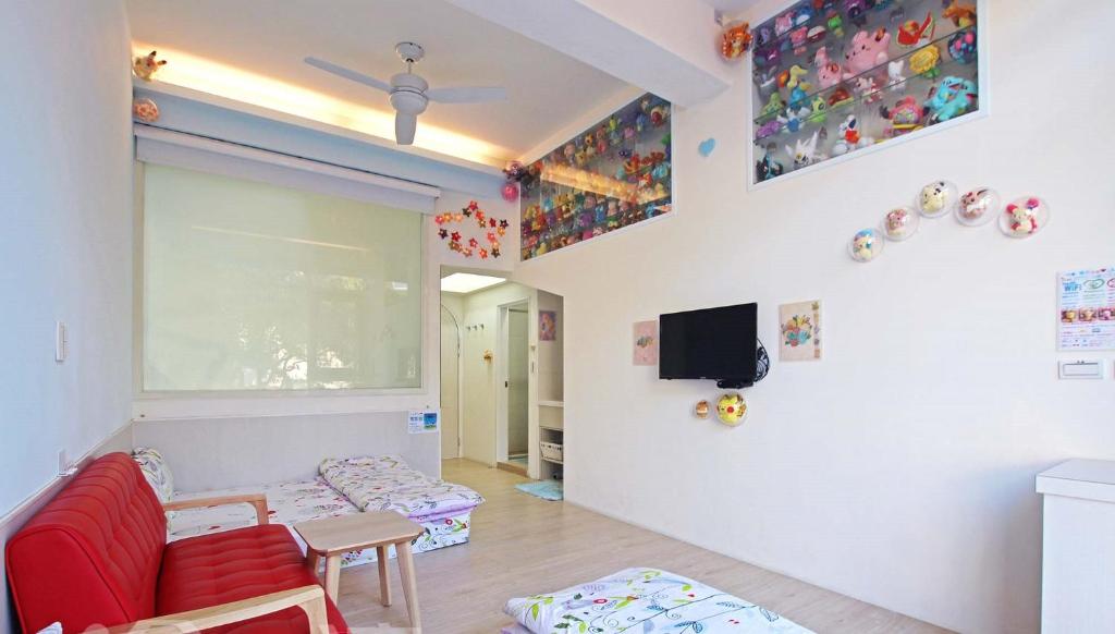 a living room with a red couch and a tv at Wan-Yue B&amp;B in Hengshan