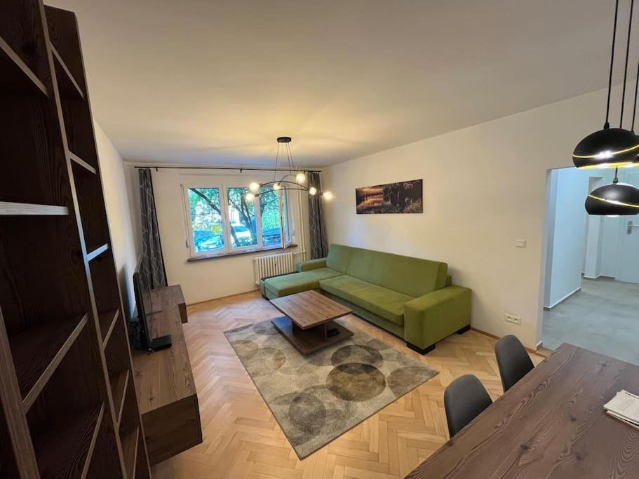 un soggiorno con divano verde e tavolo di New spacious one-room apartment a Prievoz