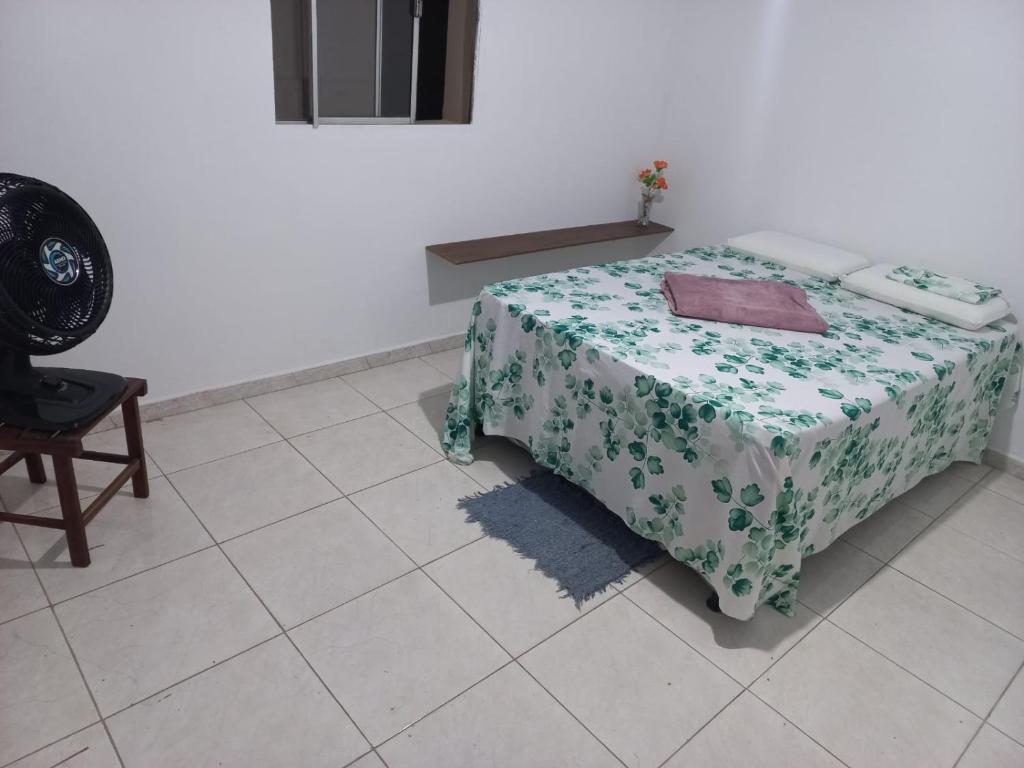 a room with a bed with a table and a chair at Casa para até 8 pessoas em Garanhuns in Garanhuns