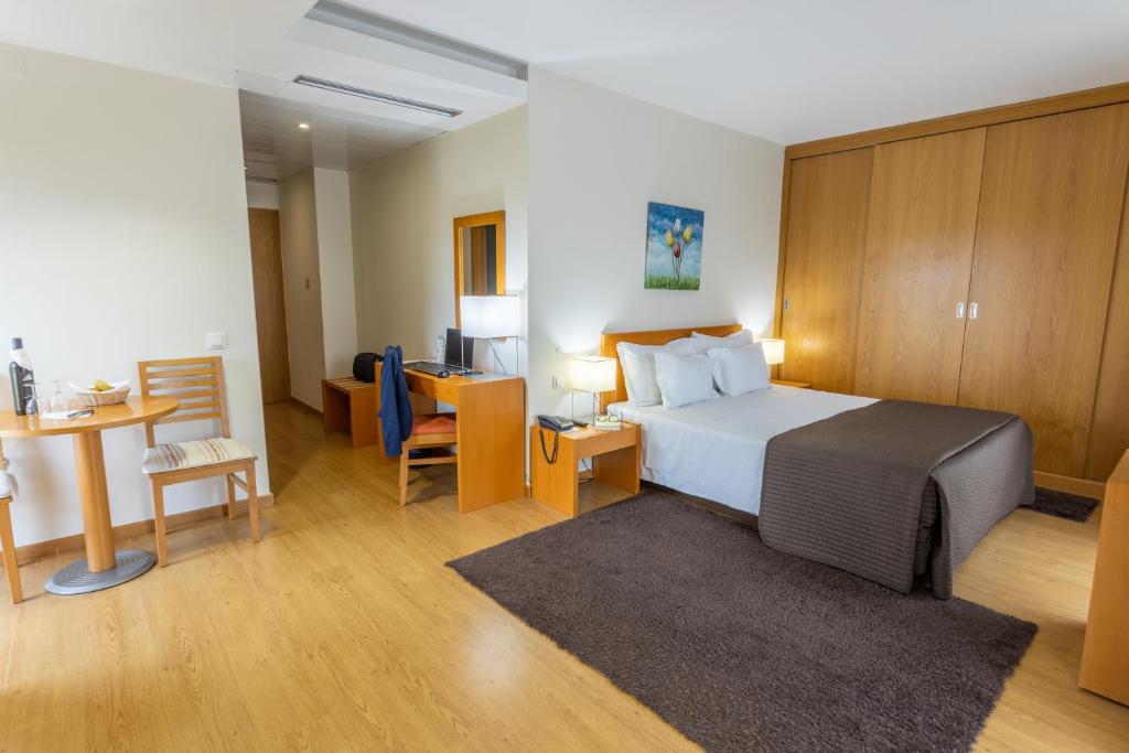 a hotel room with a bed and a desk with a computer at Eurosol Residence in Leiria