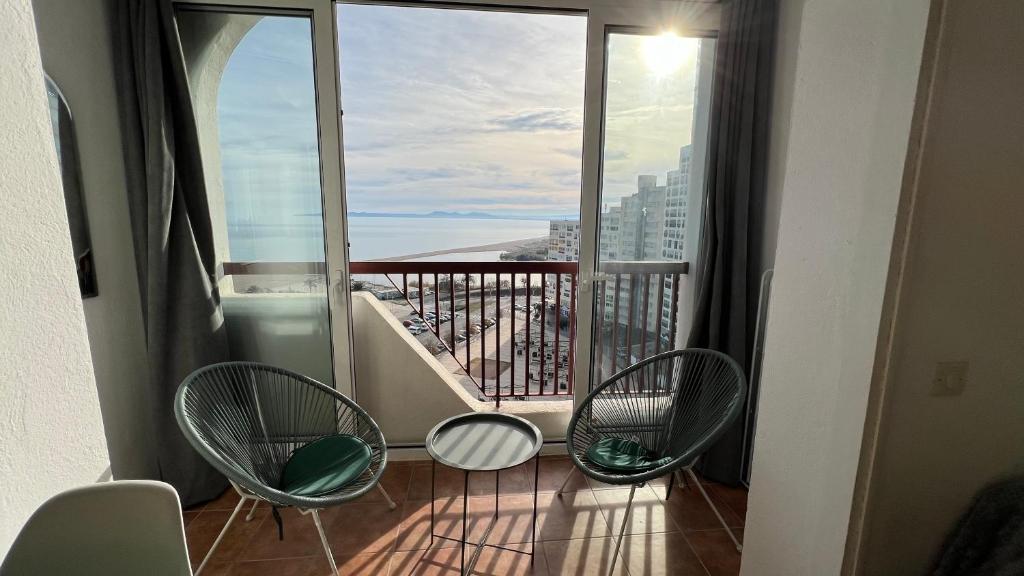 Un balcón con sillas y vistas al océano. en Bonito apartamento vista mar, en Empuriabrava