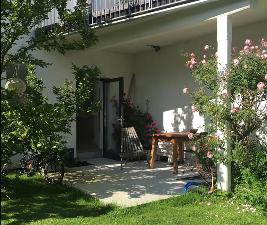 a patio with a wooden table in front of a house at Gartenstudio Peony in Innsbruck