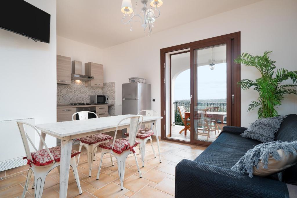 een keuken en een woonkamer met een tafel en stoelen bij Casa Parte e Sole in Posada