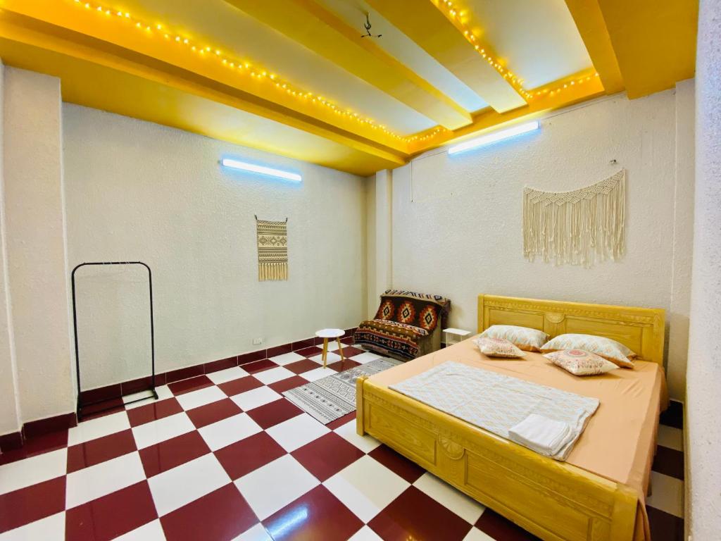 a room with a bed and a checkered floor at Dnut's House in Hanoi