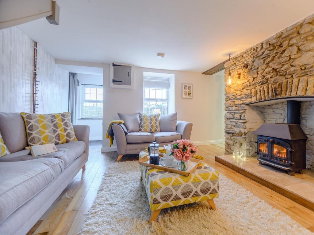 a living room with a couch and a fireplace at 2 bed property in Llandysul 77655 in Llangynllo
