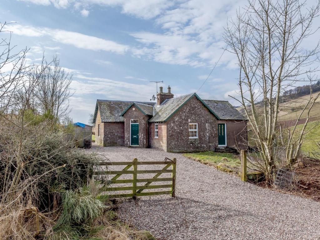 een oud huis met een hek ervoor bij 2 bed property in Kirriemuir 77494 in Kirriemuir