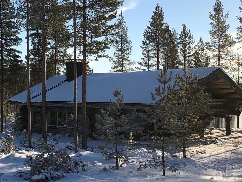 une cabine dans les bois avec de la neige sur le toit dans l'établissement Villa Kuiske, à Kuusamo