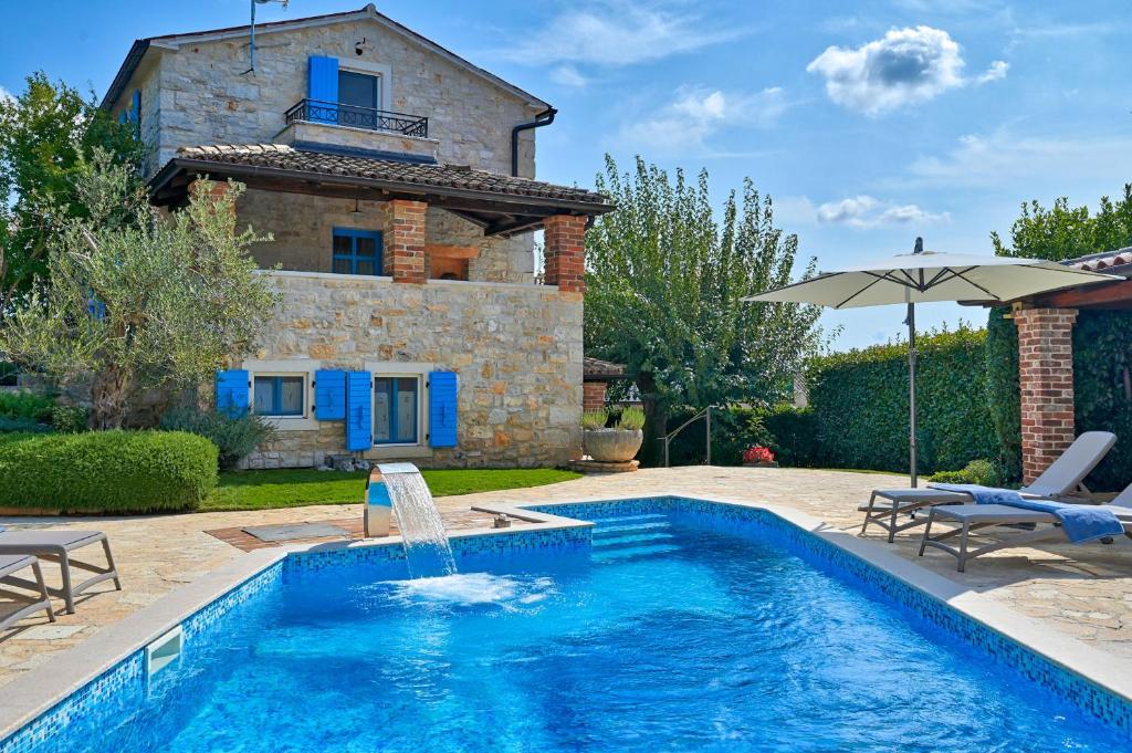 a pool in front of a villa with a house at Rustic Villa Simone with outdoor pool in Porec in Krmenjak