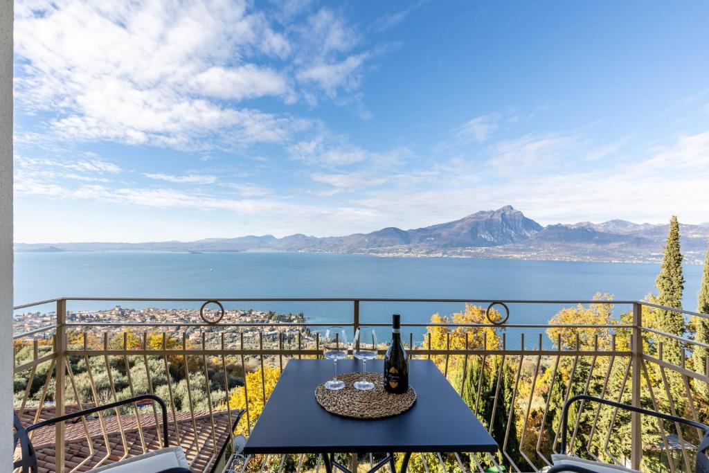 een tafel en stoelen op een balkon met uitzicht op het water bij Casa Serena in Torri del Benaco