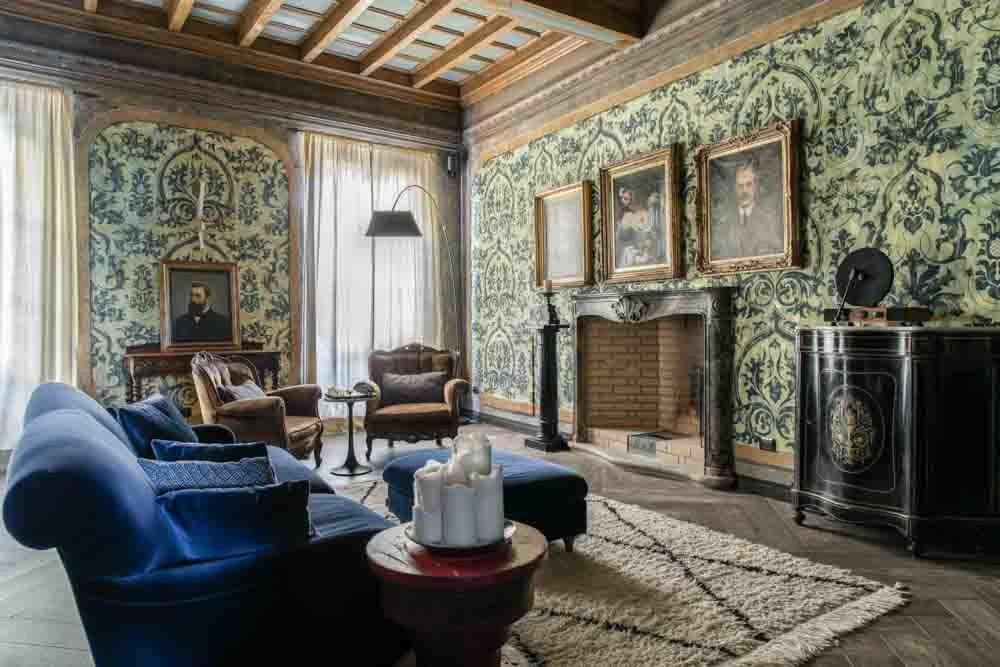 a living room with a blue couch and a fireplace at Villa Castelli in Menaggio