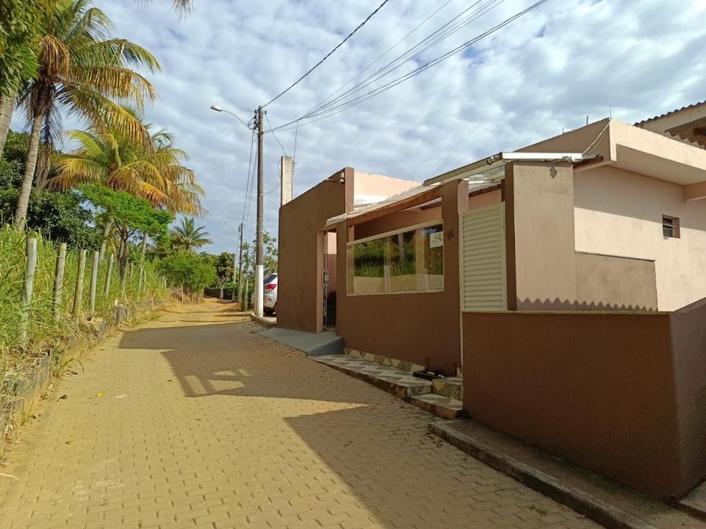 une rue vide avec une maison et des palmiers dans l'établissement Apartamento 202 Peterle Irirí, à Anchieta