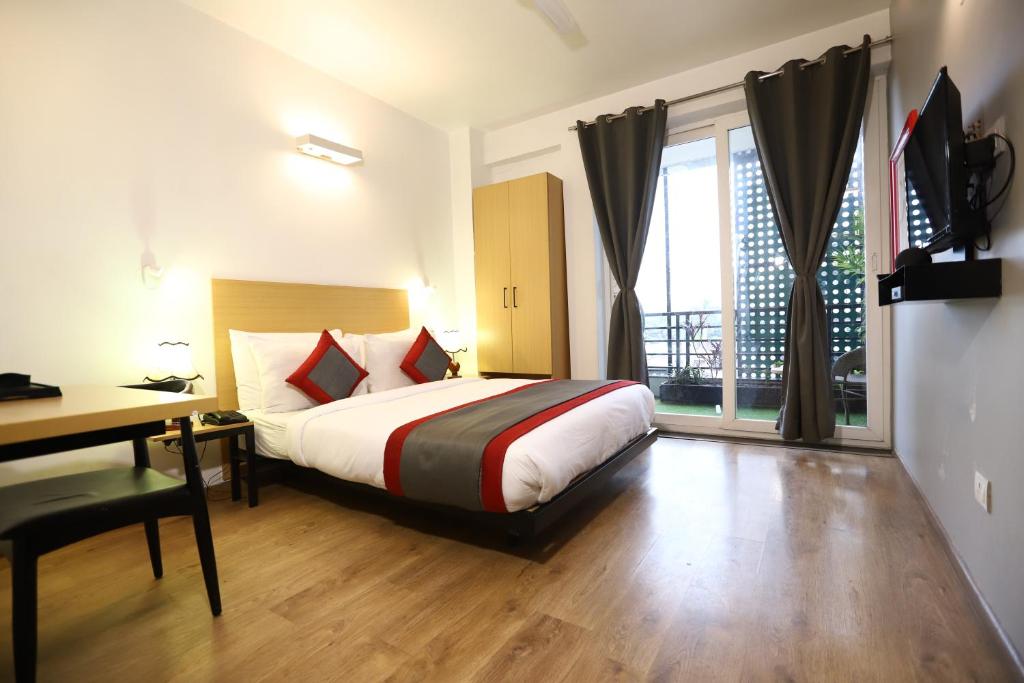 um quarto com uma cama, uma secretária e uma janela em BK Studio And Rooms Near Huda City Centre em Gurgaon