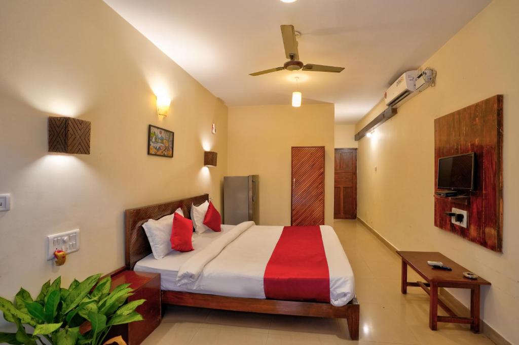 a bedroom with a bed and a television in it at Hotel Salty Waves Baga in Baga