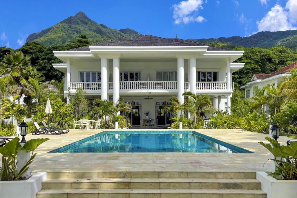 a house with a swimming pool in front of it at Chateau Elysium in Beau Vallon