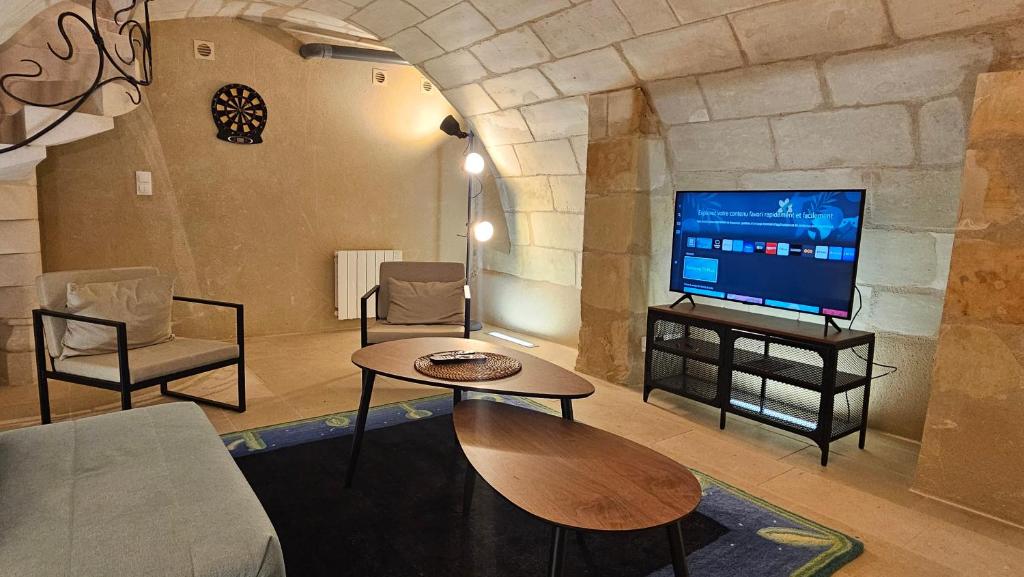 un salon avec une télévision et une table dans l'établissement Duplex élégant Tours quais de Loire, à Tours