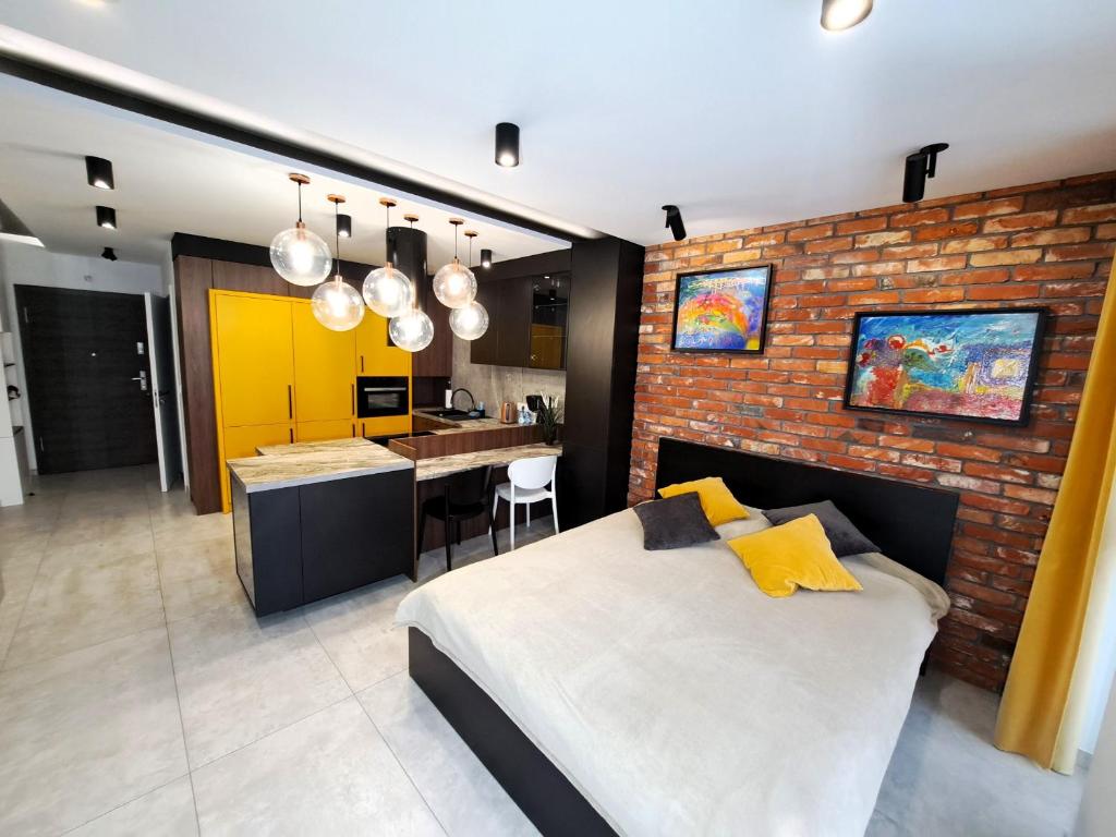 sypialnia z łóżkiem i ceglaną ścianą w obiekcie Kima Apartament Bażantów 40 w mieście Katowice