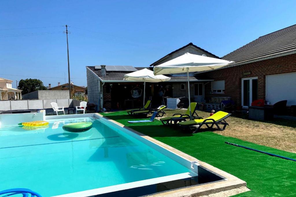 einen Pool mit Stühlen und einem Sonnenschirm in der Unterkunft Akicity Vagos Simple in Ponte de Vagos