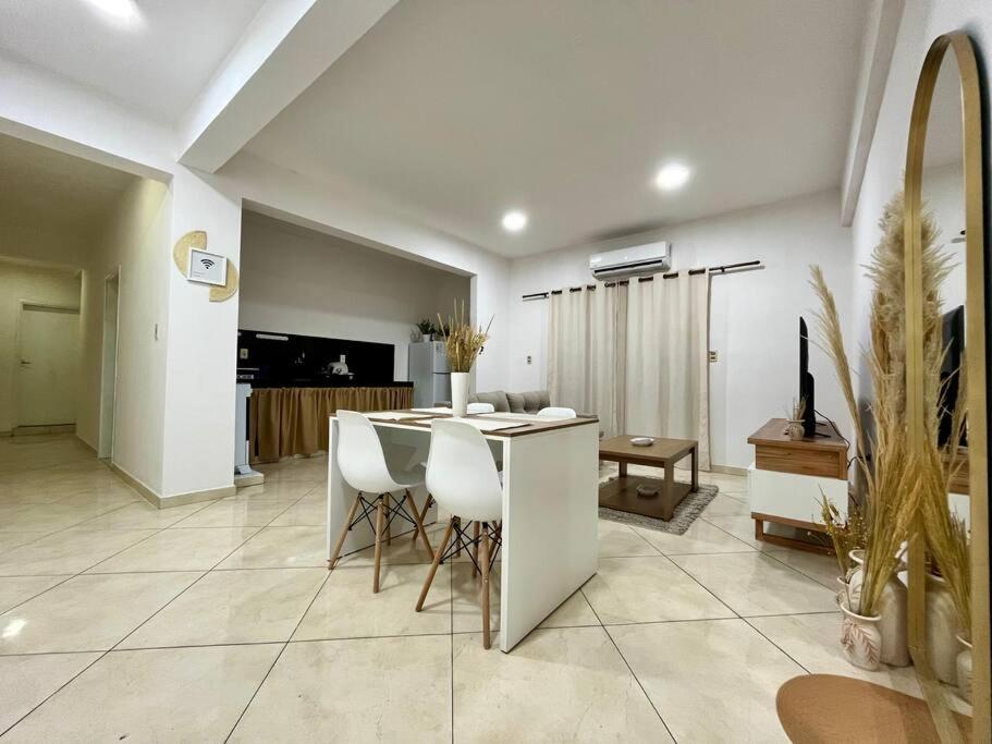 a living room with a table and chairs at Apartamento cerca del Aeropuerto in Colonia Mariano Roque Alonso