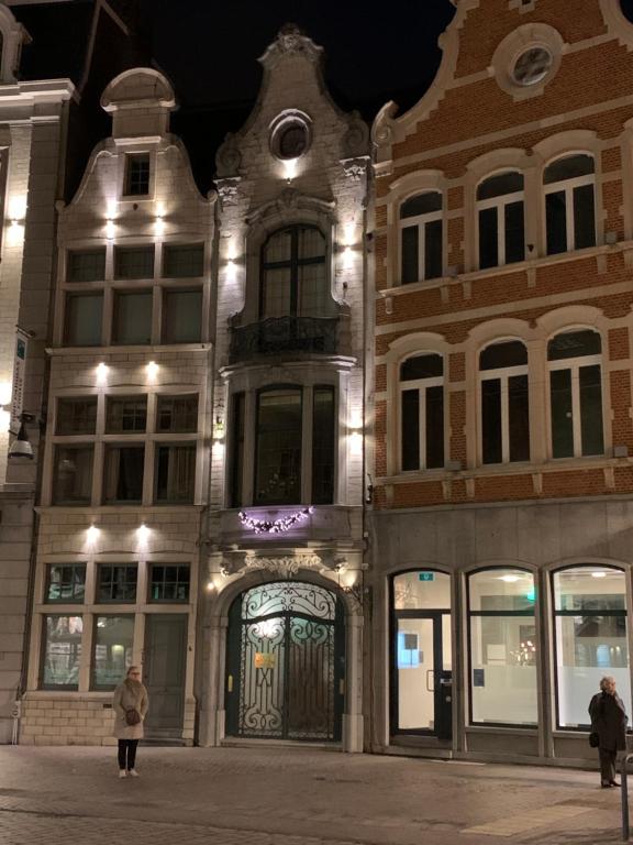 Un uomo che si trova di fronte a un edificio di notte di Markt 5 a Lier