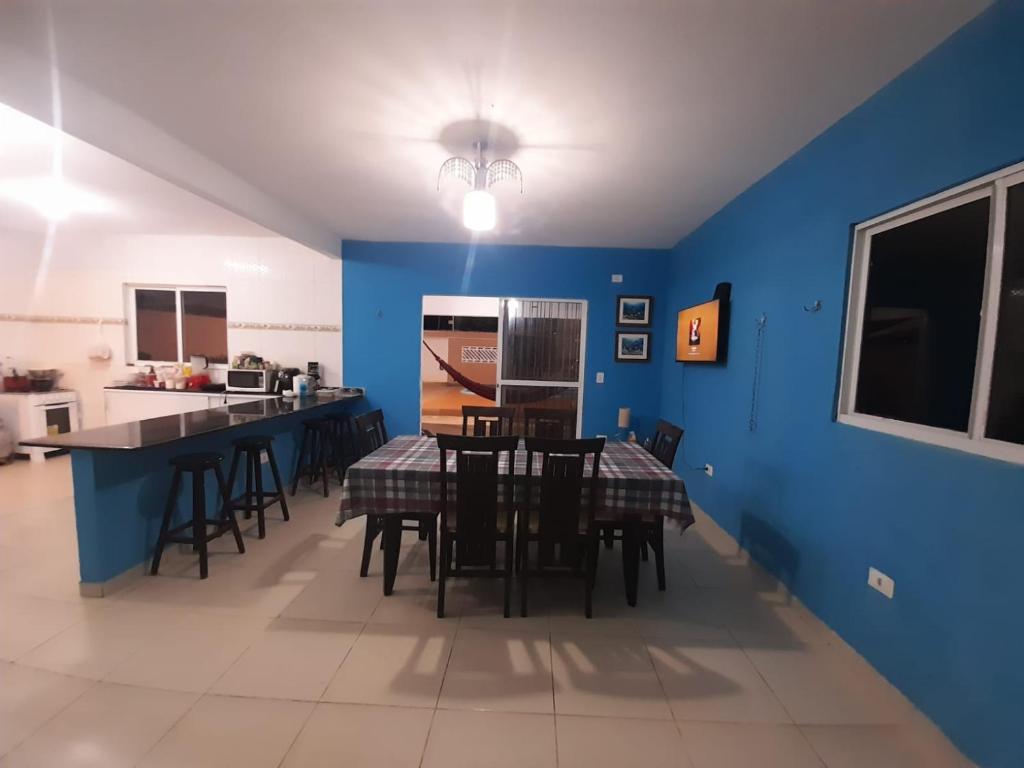 een eetkamer met blauwe muren en een tafel en stoelen bij Temporada Tamandaré in Tamandaré