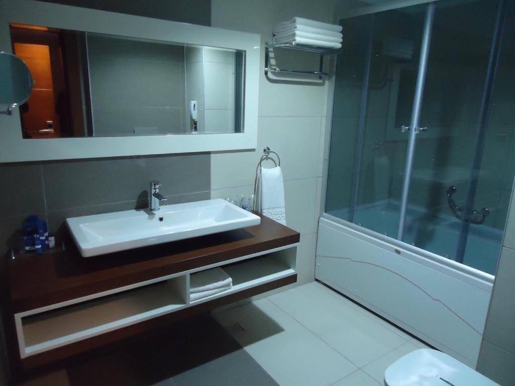 La salle de bains est pourvue d'un lavabo et d'une douche. dans l'établissement MOONLİGHT HOTEL, à Bostaniçi