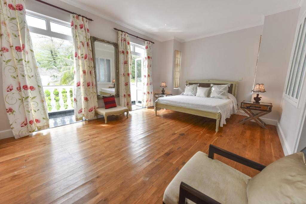 a bedroom with a bed and a large window at Chateau Elysium in Beau Vallon