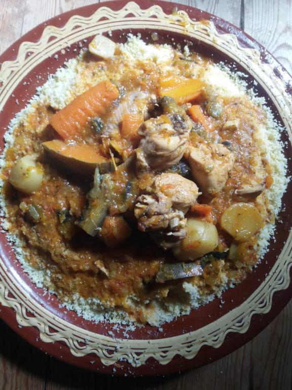eine Schüssel mit Fleisch und Gemüse auf dem Tisch in der Unterkunft Raha Cave Said in Douaïra