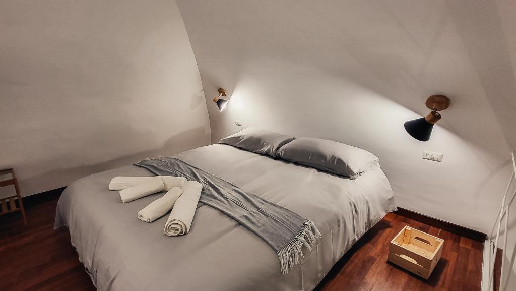 een slaapkamer met een bed met witte lakens en kussens bij Duomo Holiday in Napels