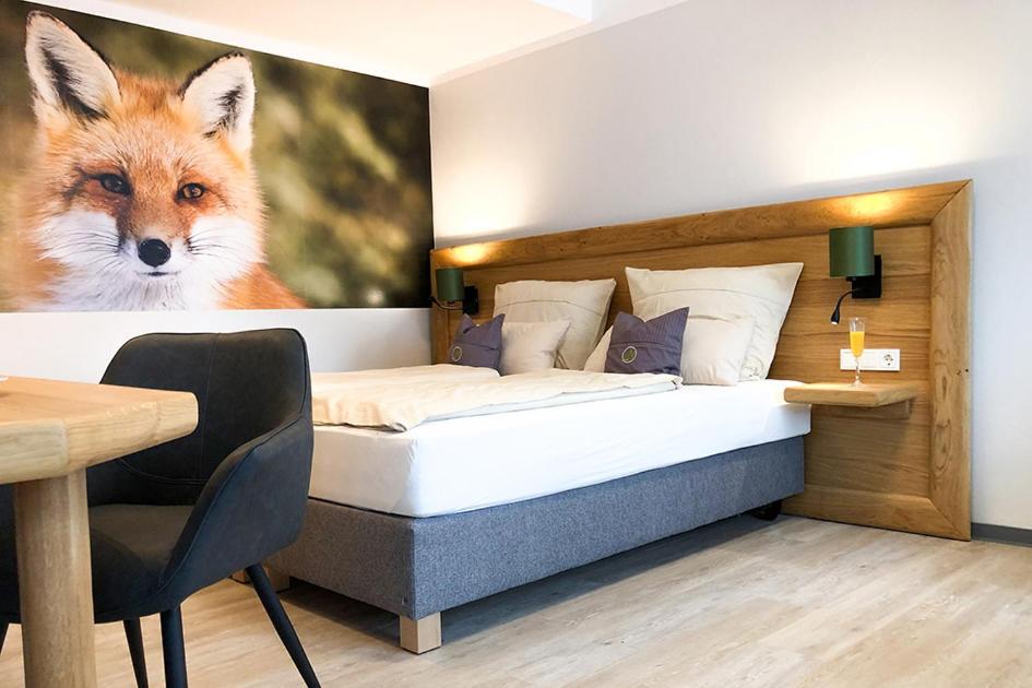 a bedroom with a bed with a painting of a fox at Landhotel Napoleon in Wipperfürth
