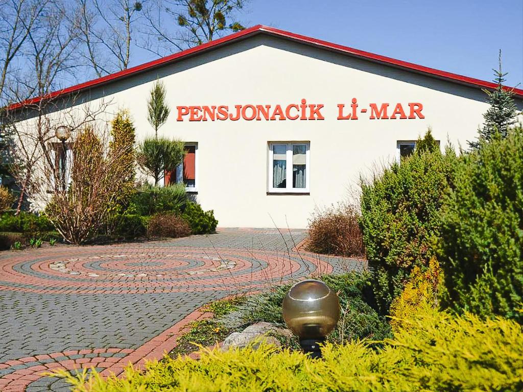 a building with a sign on the side of it at Pensjonat Li-Mar in Pisz