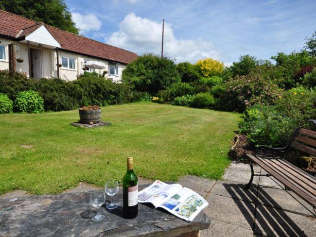 a bottle of wine sitting on a table in a yard at 2 Bed in Bampton SHAYN in Huntsham