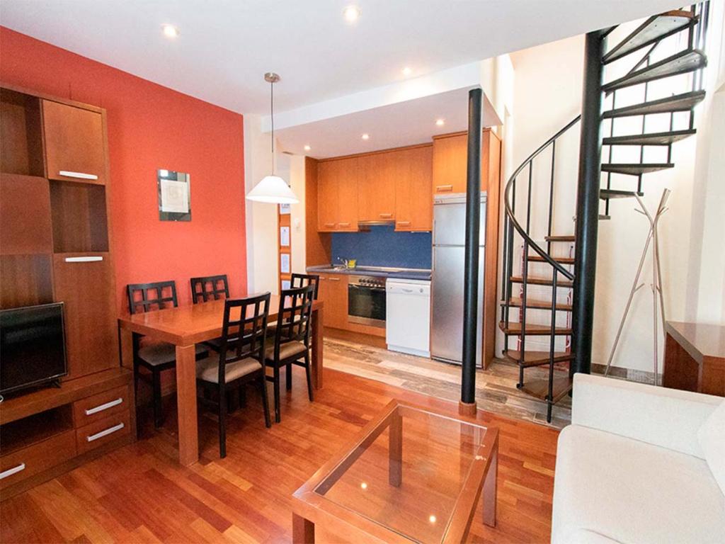 eine Küche und ein Esszimmer mit einem Tisch und Stühlen in der Unterkunft Apartamentos Villanua 3000 in Villanúa
