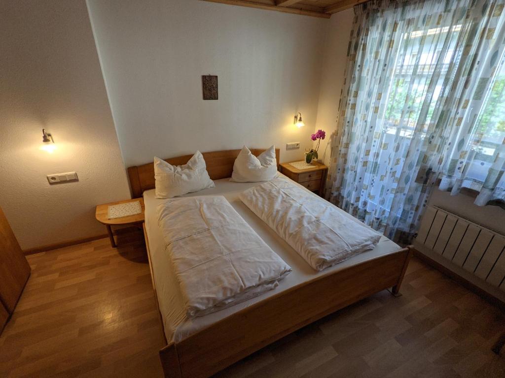 a bedroom with a bed with white sheets and a window at Appartement Egart 1 in Resia