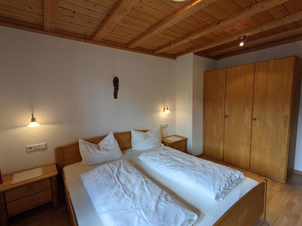 een slaapkamer met een bed met witte lakens en kussens bij Appartement Egart 2 in Resia