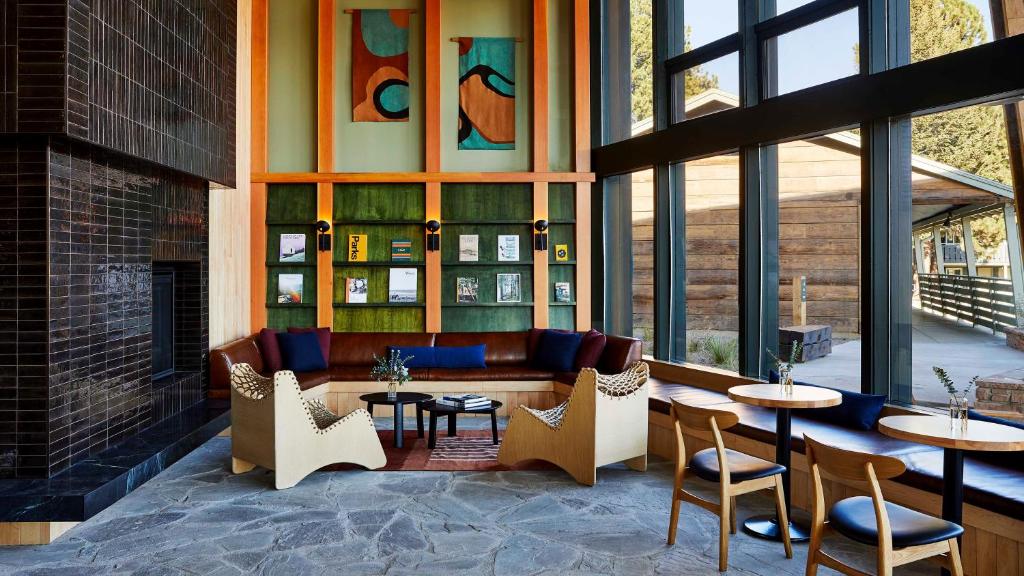 a restaurant with tables and chairs and a fireplace at Trailborn Rocky Mountains in Estes Park