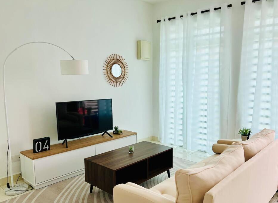 Cozy Scandi home @ Balok! في Kampung Saberang Balok: غرفة معيشة مع أريكة وتلفزيون بشاشة مسطحة