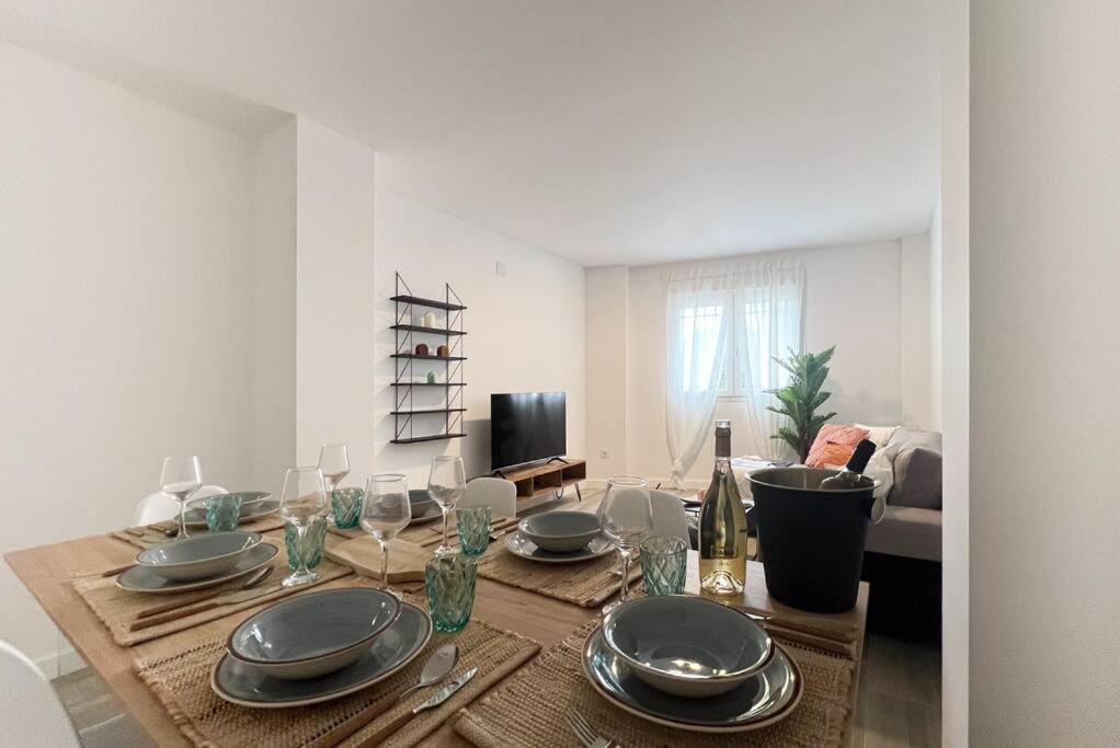 a dining room table with plates and wine glasses at Apartamentos Gredos 001 in Jaraiz de la Vera