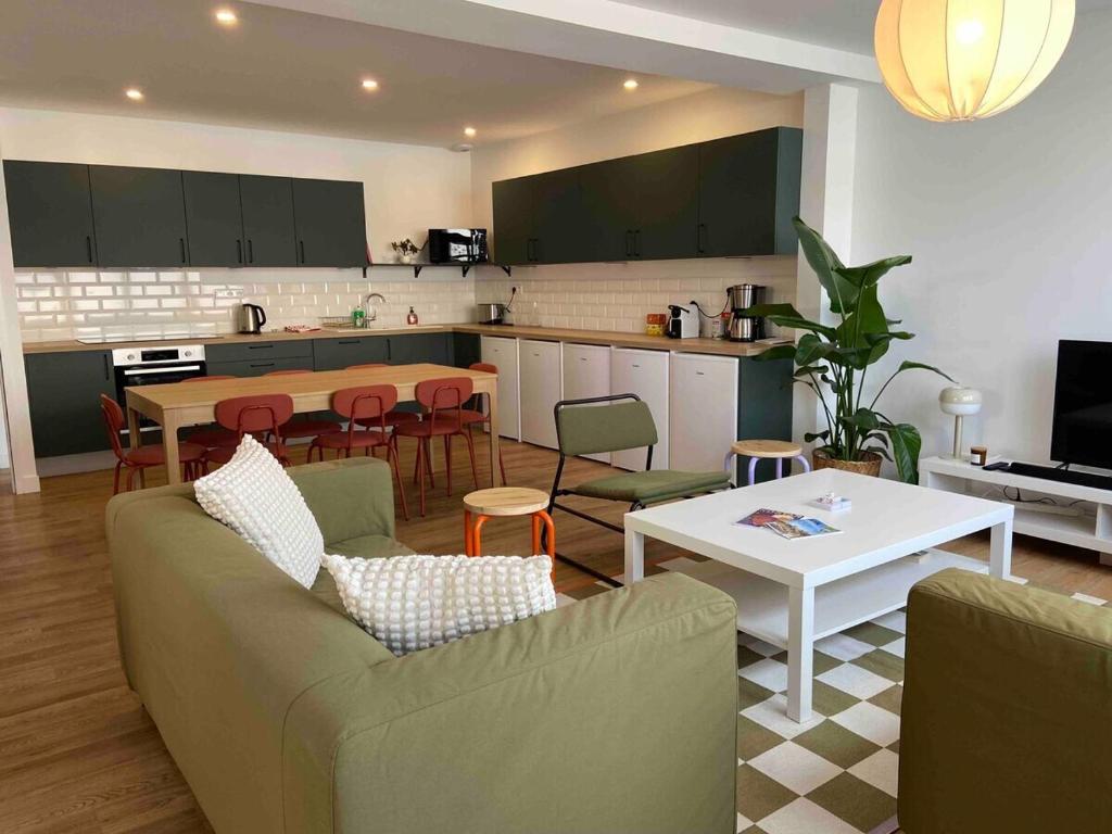 昂熱的住宿－La Casa Calot，厨房以及带沙发和桌子的客厅。