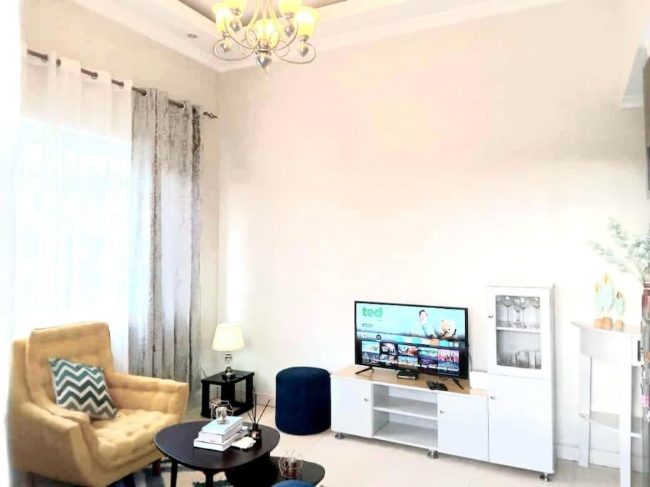 a living room with a tv and a chair and a table at Spacious, Scenic & Homely Loft in Kigali