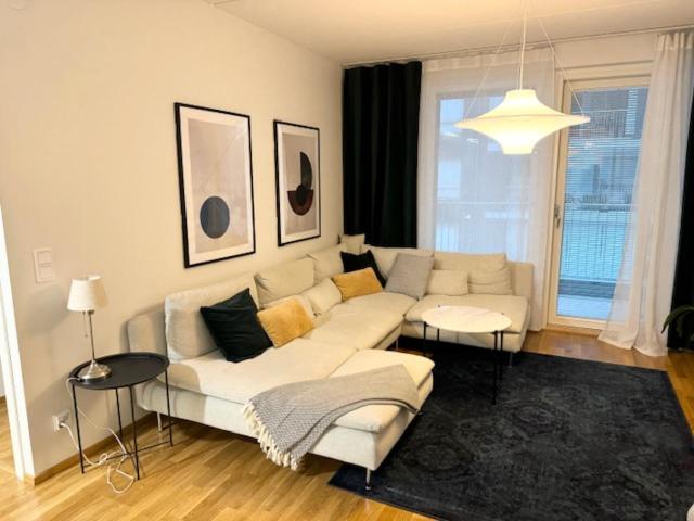 a living room with a white couch and a table at JATKASAARI-2 - Chic and cosy Sea side stay in Helsinki