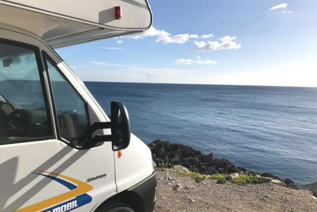 a white van parked next to the ocean at Akisol Azeitão Ride in Azeitao